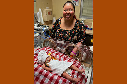 NICU Nurse Tai Smith dressing baby chef