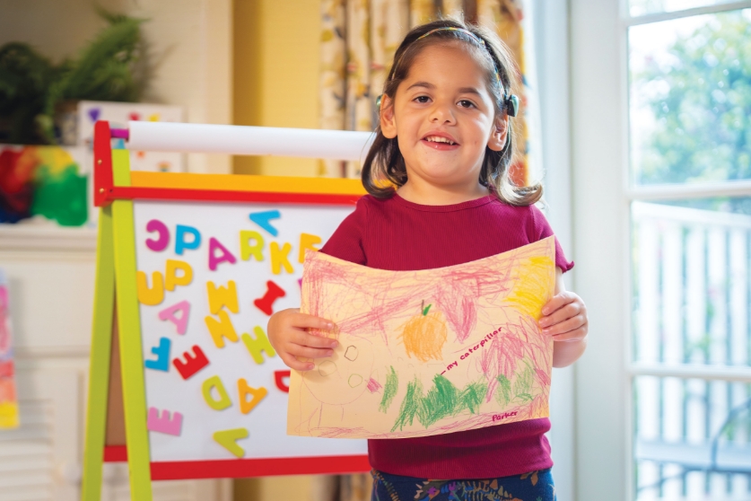 Fight the Unfair with nationally ranked and award-winning pediatric care. Parker holding painting.